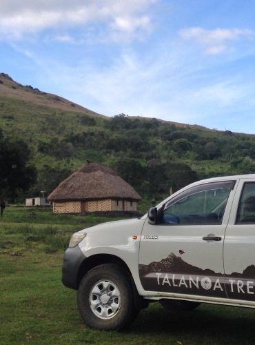 A truck parked near a traditional Fijian bure in Nubutautau