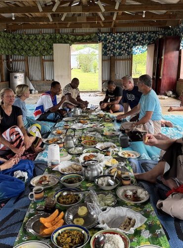 Guests eating breakfast in a Fijian highland village